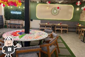 A cafe with a table and chairs decorated with balloons.